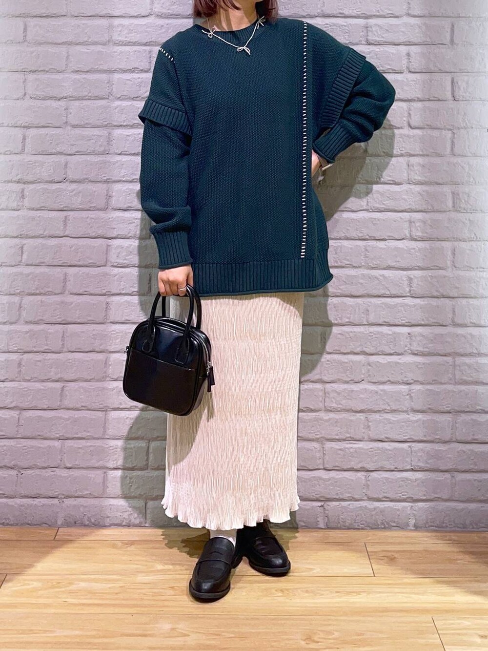 ブラック系のローファー、グリーン系のTシャツ/カットソー、ブラック系のボストンバッグを着用したレディースの秋コーディネートの2枚目の写真