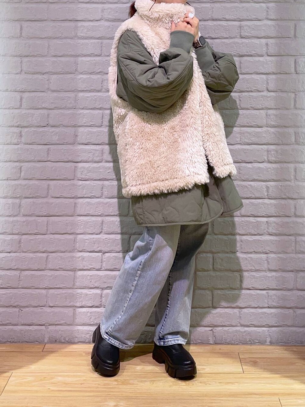 ホワイト系のTシャツ/カットソー、ブラック系のブーツ、ブルー系のデニムパンツを着用したレディースの秋コーディネートの2枚目の写真