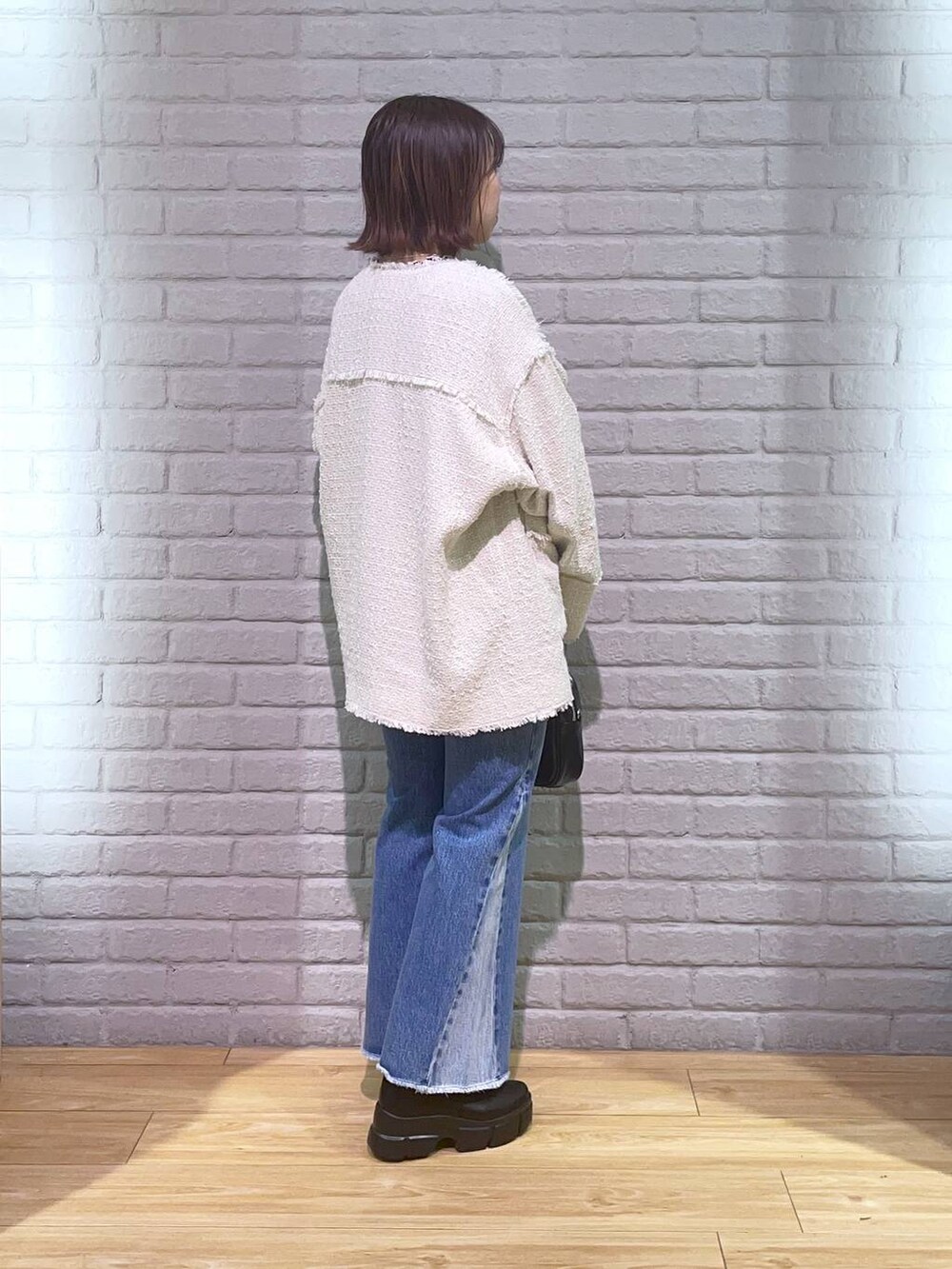 ホワイト系のTシャツ/カットソー、ブラック系のブーツ、その他のデニムパンツを着用したレディースの秋コーディネートの3枚目の写真