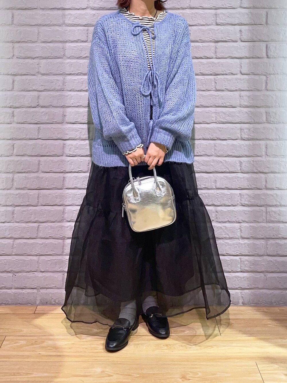 ブラック系のローファー、ブラック系のスカート、ブルー系のニット/セーターを着用したレディースの秋コーディネートの2枚目の写真