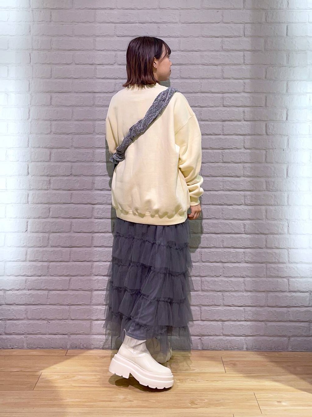 ホワイト系のTシャツ/カットソー、シルバー系のショルダーバッグ、ホワイト系のブーツを着用したレディースの秋コーディネートの3枚目の写真