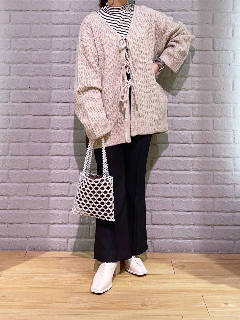 ホワイト系のTシャツ/カットソー、ホワイト系のパンプス、ホワイト系のショルダーバッグを着用したレディースの秋コーディネートの2枚目の写真