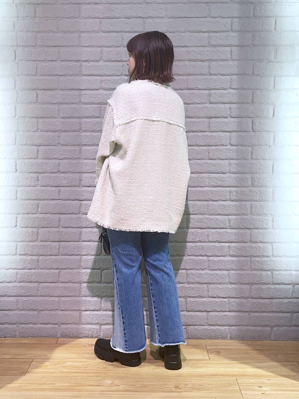 ホワイト系のTシャツ/カットソー、ブラック系のブーツ、その他のデニムパンツを着用したレディースの秋コーディネートの4枚目の写真