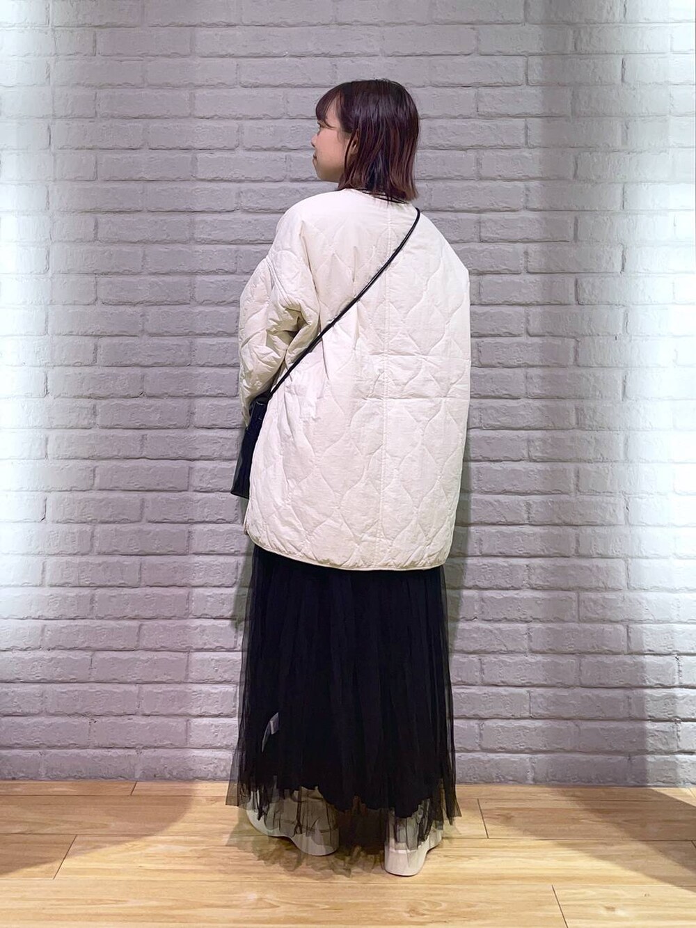 ホワイト系のTシャツ/カットソー、ホワイト系のブルゾン、ホワイト系のブーツを着用したレディースの秋コーディネートの3枚目の写真