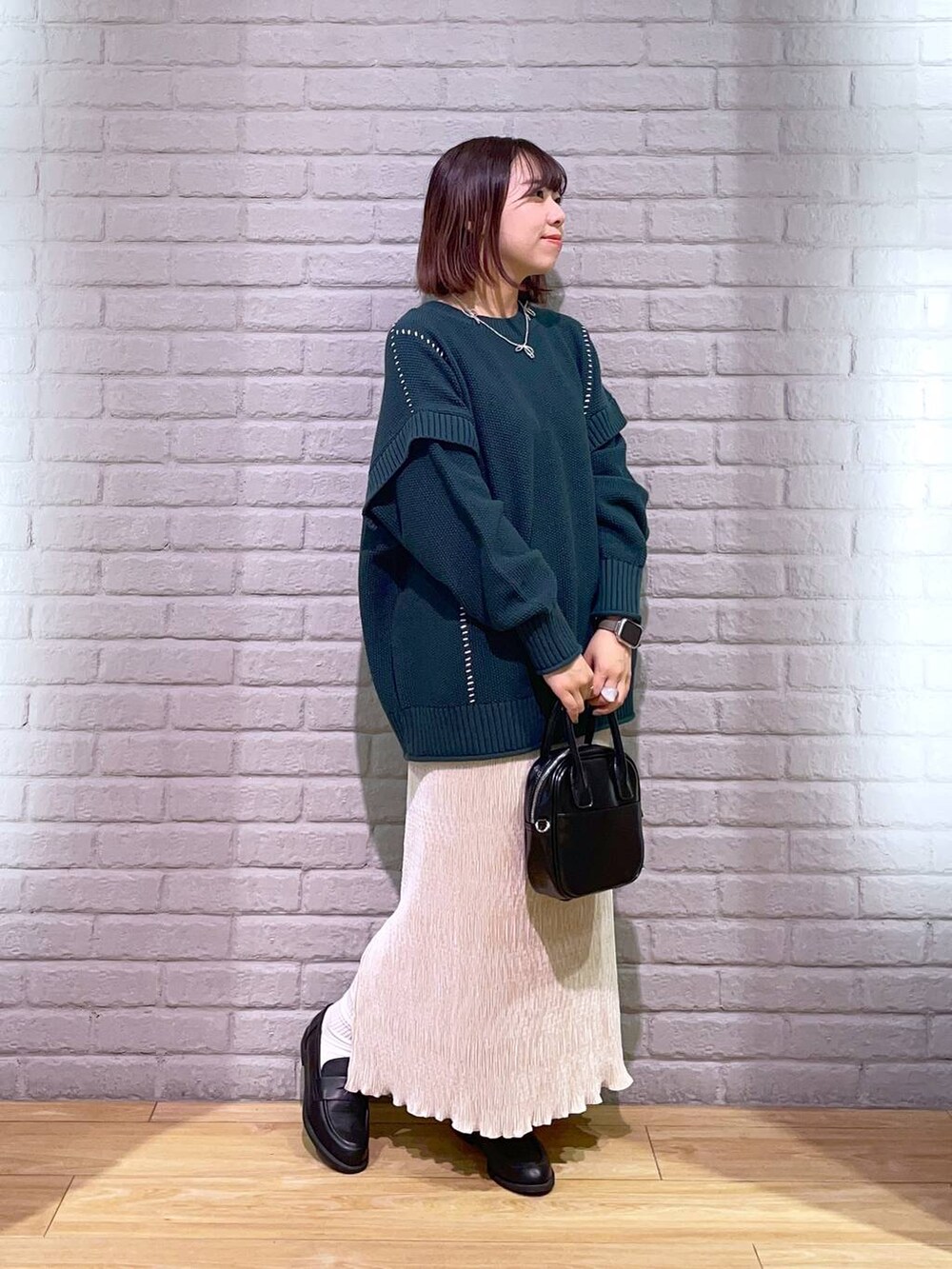 ブラック系のローファー、グリーン系のTシャツ/カットソー、ブラック系のボストンバッグを着用したレディースの秋コーディネートの4枚目の写真