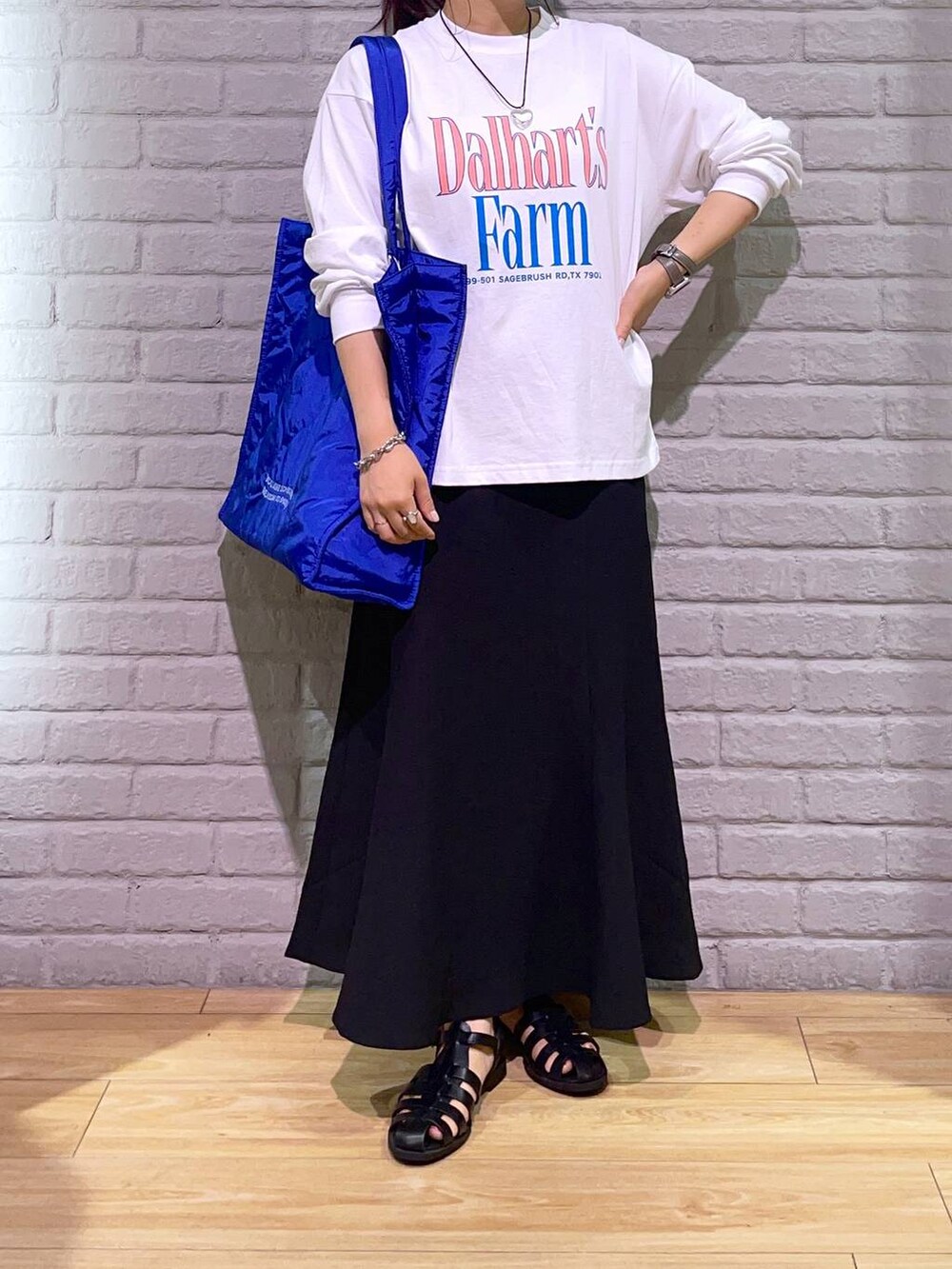 ブラック系のサンダル、ブラック系のスカート、ブルー系のショルダーバッグを着用したレディースの夏コーディネートの2枚目の写真