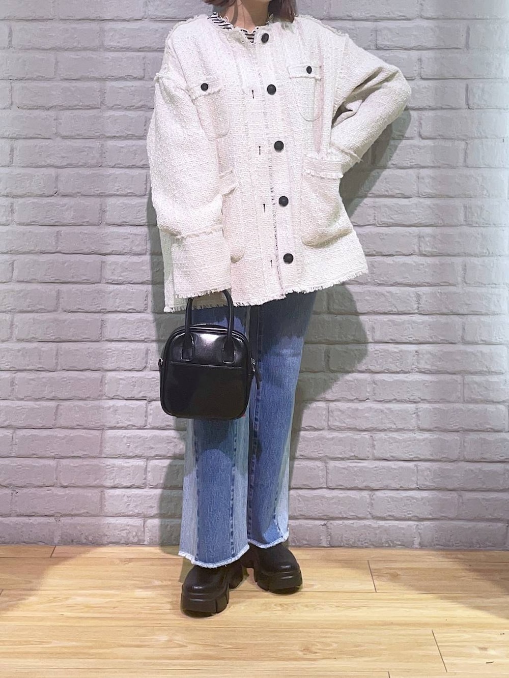 ホワイト系のTシャツ/カットソー、ブラック系のブーツ、その他のデニムパンツを着用したレディースの秋コーディネートの2枚目の写真