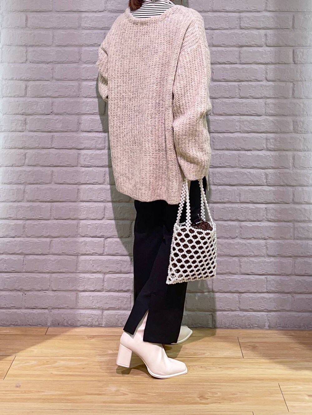 ホワイト系のTシャツ/カットソー、ホワイト系のパンプス、ホワイト系のショルダーバッグを着用したレディースの秋コーディネートの3枚目の写真