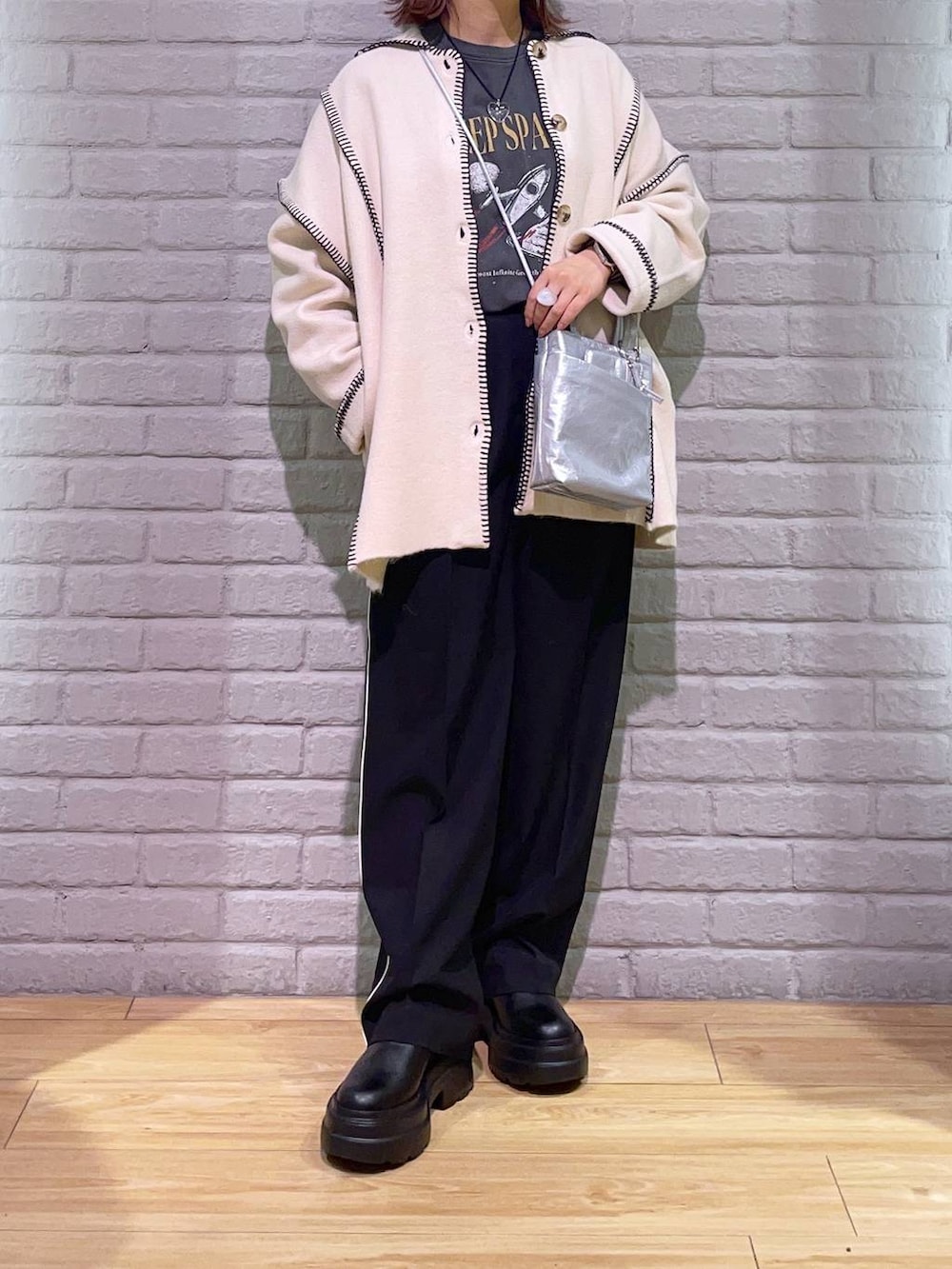 ブラック系のその他パンツ、ブラック系のブーツ、シルバー系のショルダーバッグを着用したレディースの秋コーディネートの2枚目の写真