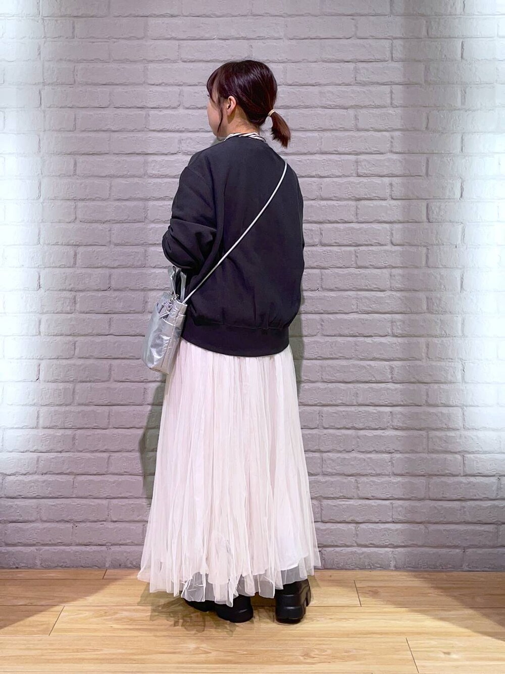 ホワイト系のTシャツ/カットソー、ブラック系のブーツ、シルバー系のショルダーバッグを着用したレディースの秋コーディネートの3枚目の写真