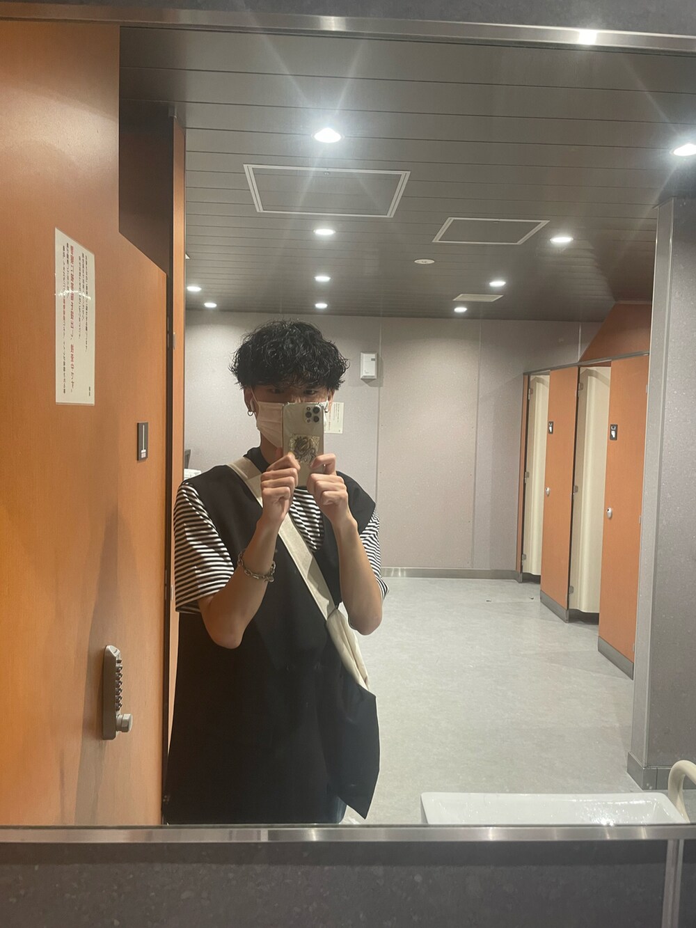 ブラック系のベスト、ブラック系のTシャツ/カットソー、ホワイト系のショルダーバッグを着用したメンズの秋コーディネートの3枚目の写真