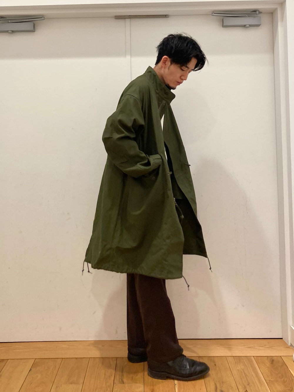 ブラック系のドレスシューズ、ホワイト系のシャツ/ブラウス、グリーン系のモッズコートを着用したメンズの冬コーディネートの2枚目の写真