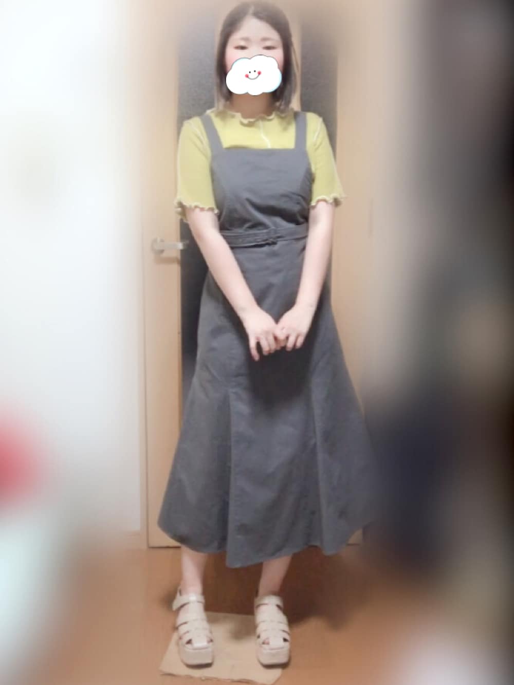 ベージュ系のサンダル、イエロー系のTシャツ/カットソー、グレー系のジャンパースカートを着用したレディースの夏コーディネートの2枚目の写真