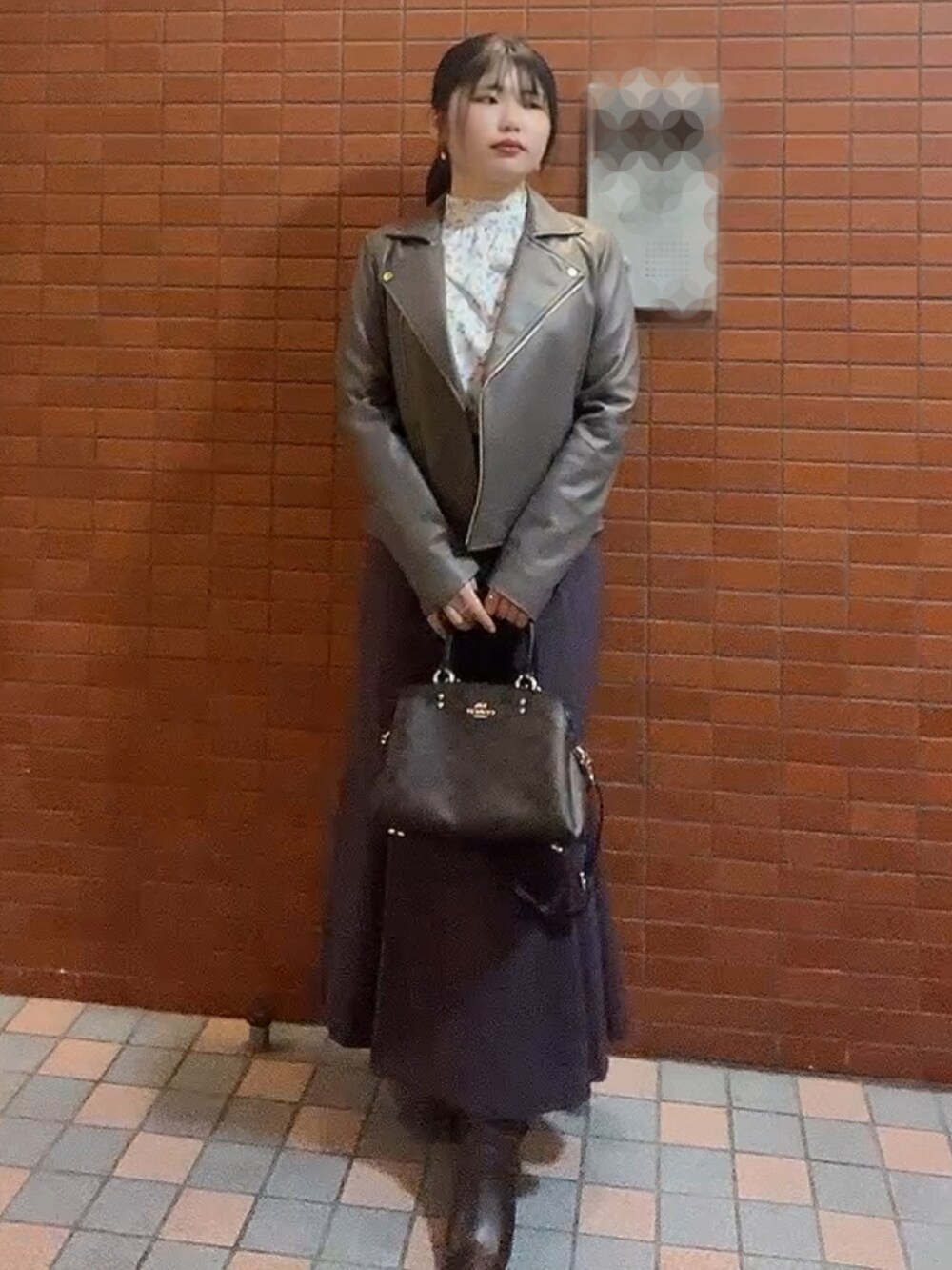 ブラウン系のショルダーバッグ、グレー系のライダースジャケット、ホワイト系のシャツ/ブラウスを着用したレディースの秋コーディネートの2枚目の写真