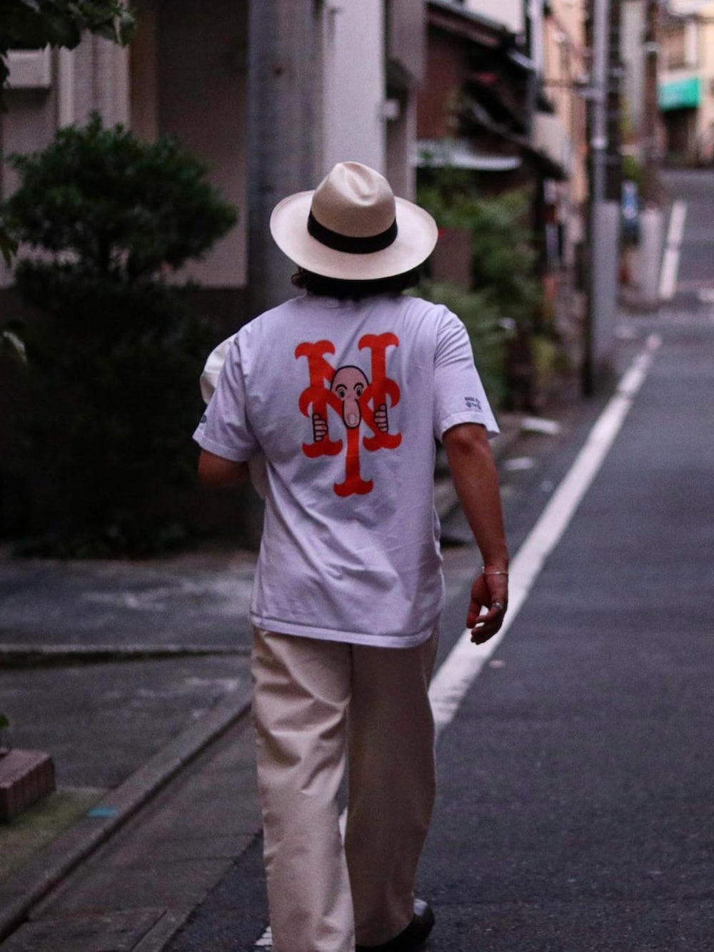 ホワイト系のTシャツ/カットソー、ホワイト系のデニムパンツ、ブラック系のブーツを着用したメンズの夏コーディネートの2枚目の写真