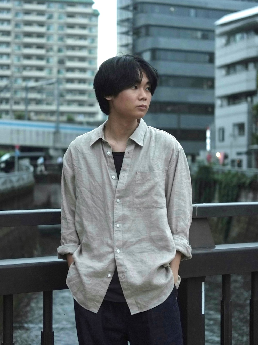 ブルー系のデニムパンツ、ベージュ系のシャツ/ブラウス、ブラック系のタンクトップを着用したメンズの夏コーディネートの2枚目の写真