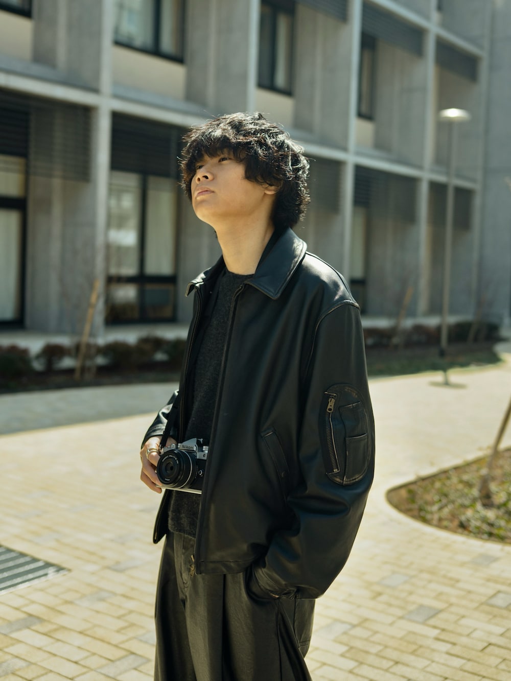 ブラック系のスラックス、ブラック系のブルゾン、ブラック系のブーツを着用したメンズの春コーディネートの2枚目の写真