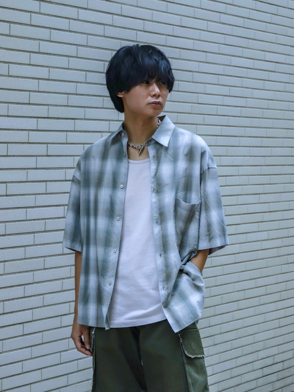 グレー系のシャツ/ブラウス、グレー系のタンクトップ、グリーン系のカーゴパンツを着用したメンズの夏コーディネートの2枚目の写真