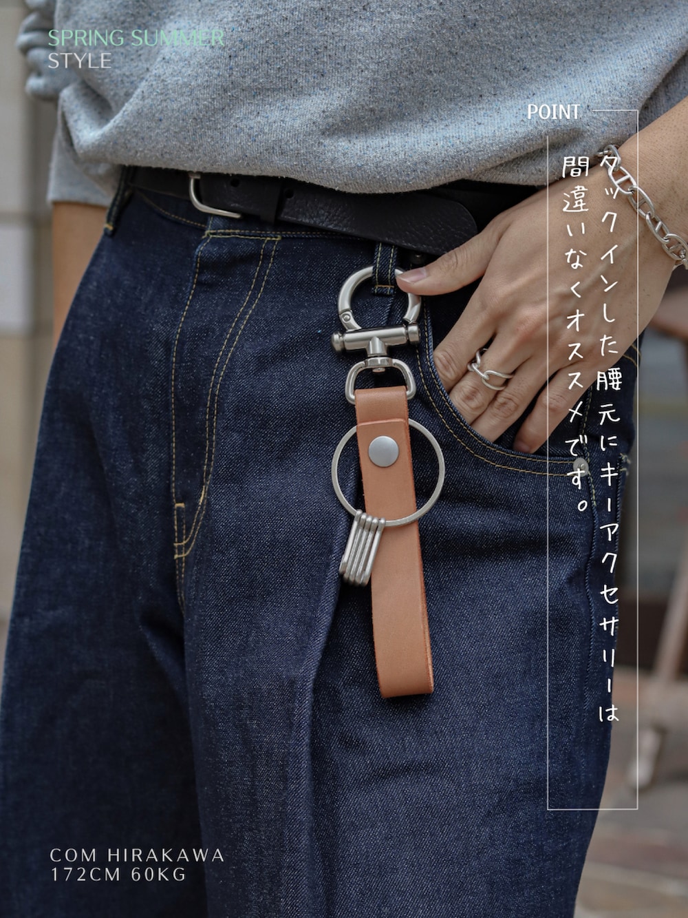 グレー系のスウェット、ブルー系のデニムパンツ、ブラック系のスニーカーを着用したメンズの春コーディネートの3枚目の写真