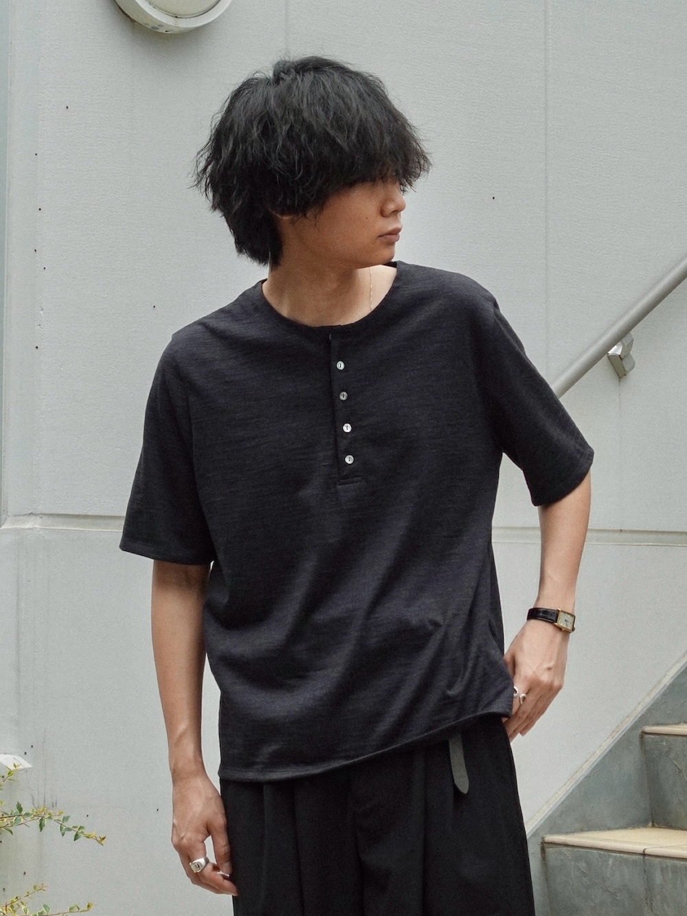 ブラック系のスラックス、ブラック系のサンダル、ブラック系のTシャツ/カットソーを着用したメンズの夏コーディネートの2枚目の写真