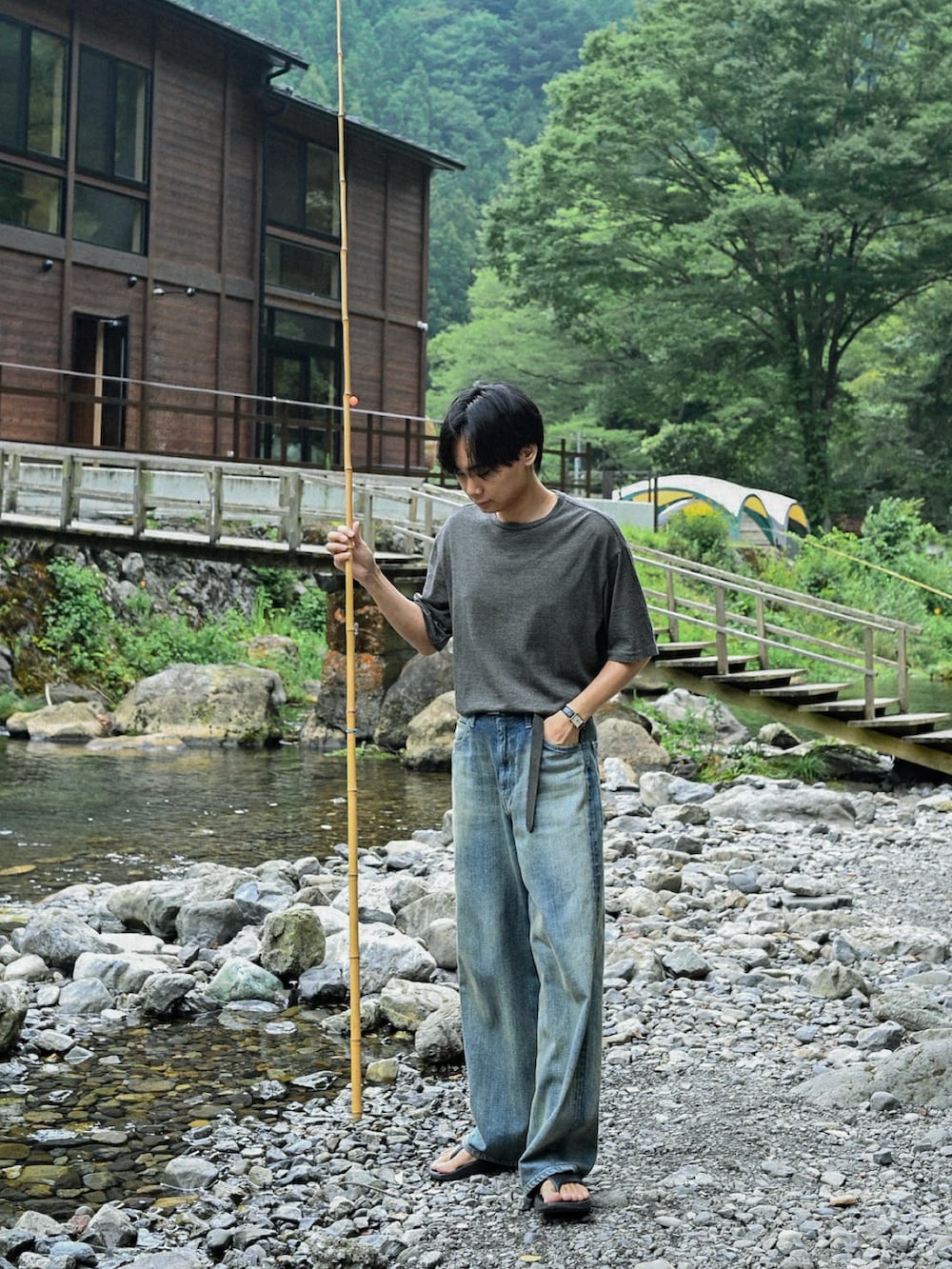 ブラック系のサンダル、イエロー系のTシャツ/カットソー、ブルー系のデニムパンツを着用したメンズの夏コーディネートの2枚目の写真