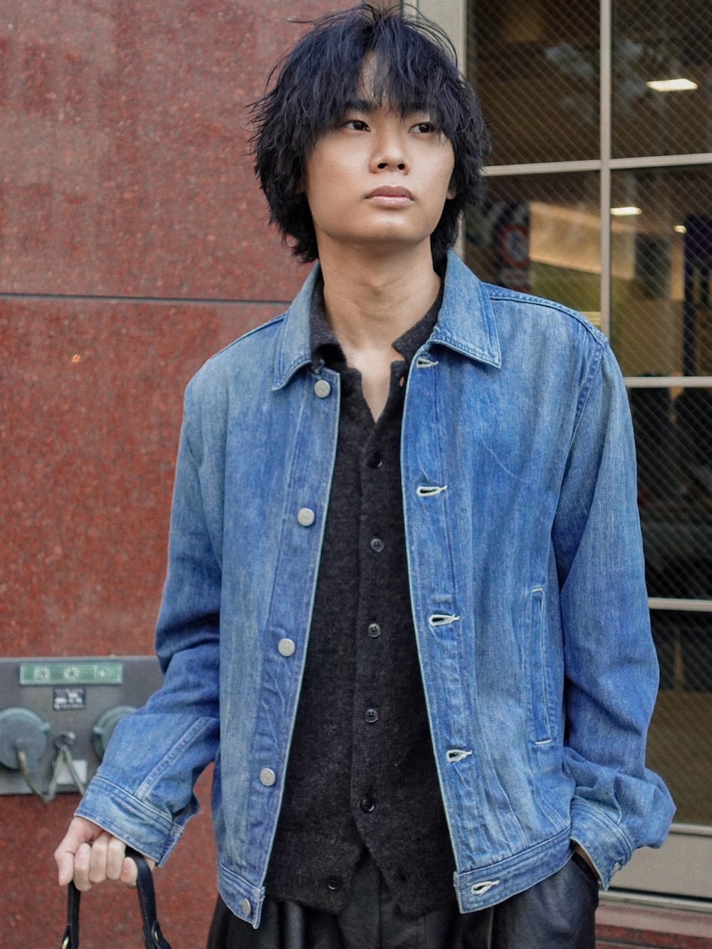 ブラック系のスラックス、ブラック系のブーツ、ブラック系のカーディガン/ボレロを着用したメンズの冬コーディネートの2枚目の写真