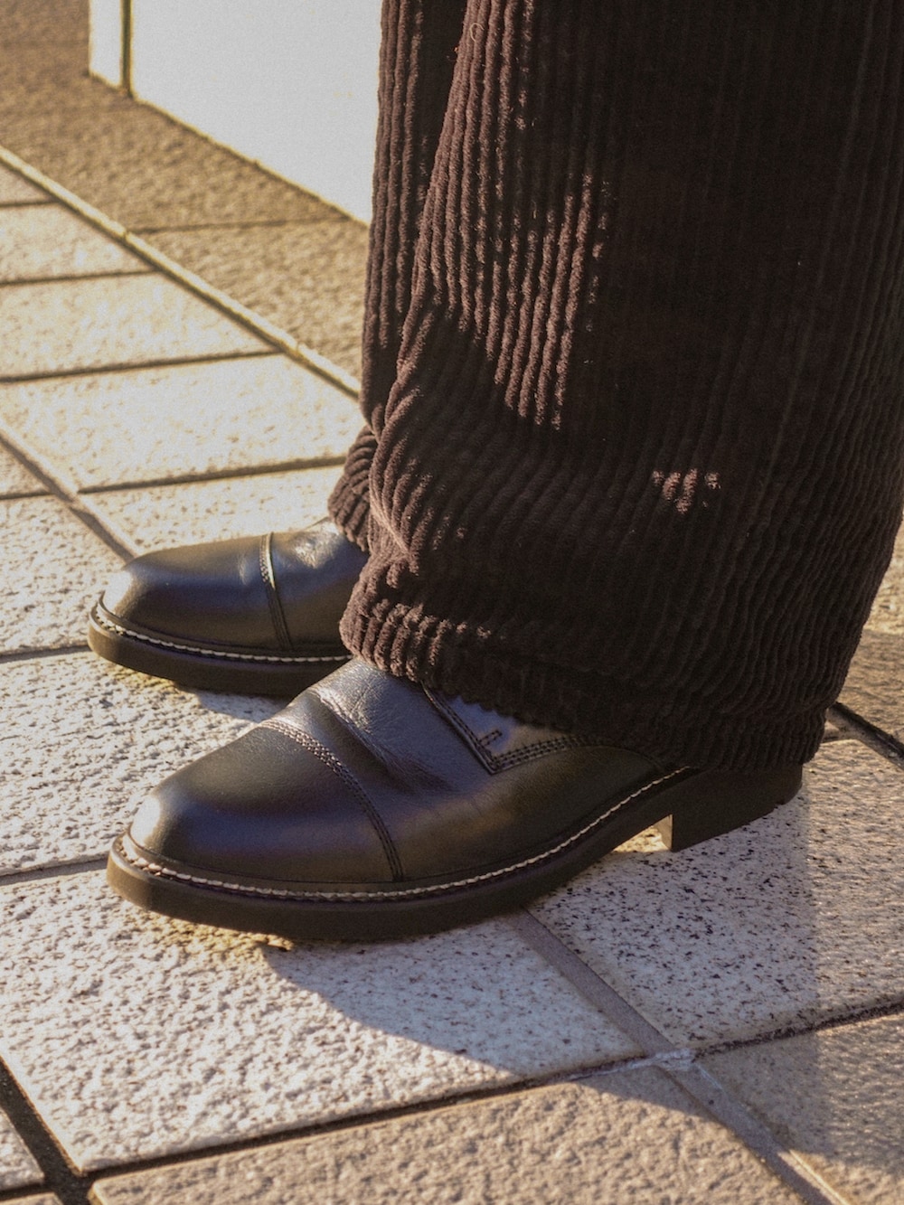 ブラック系のドレスシューズ、ブラウン系のニット/セーター、ブラウン系のブルゾンを着用したメンズの冬コーディネートの3枚目の写真