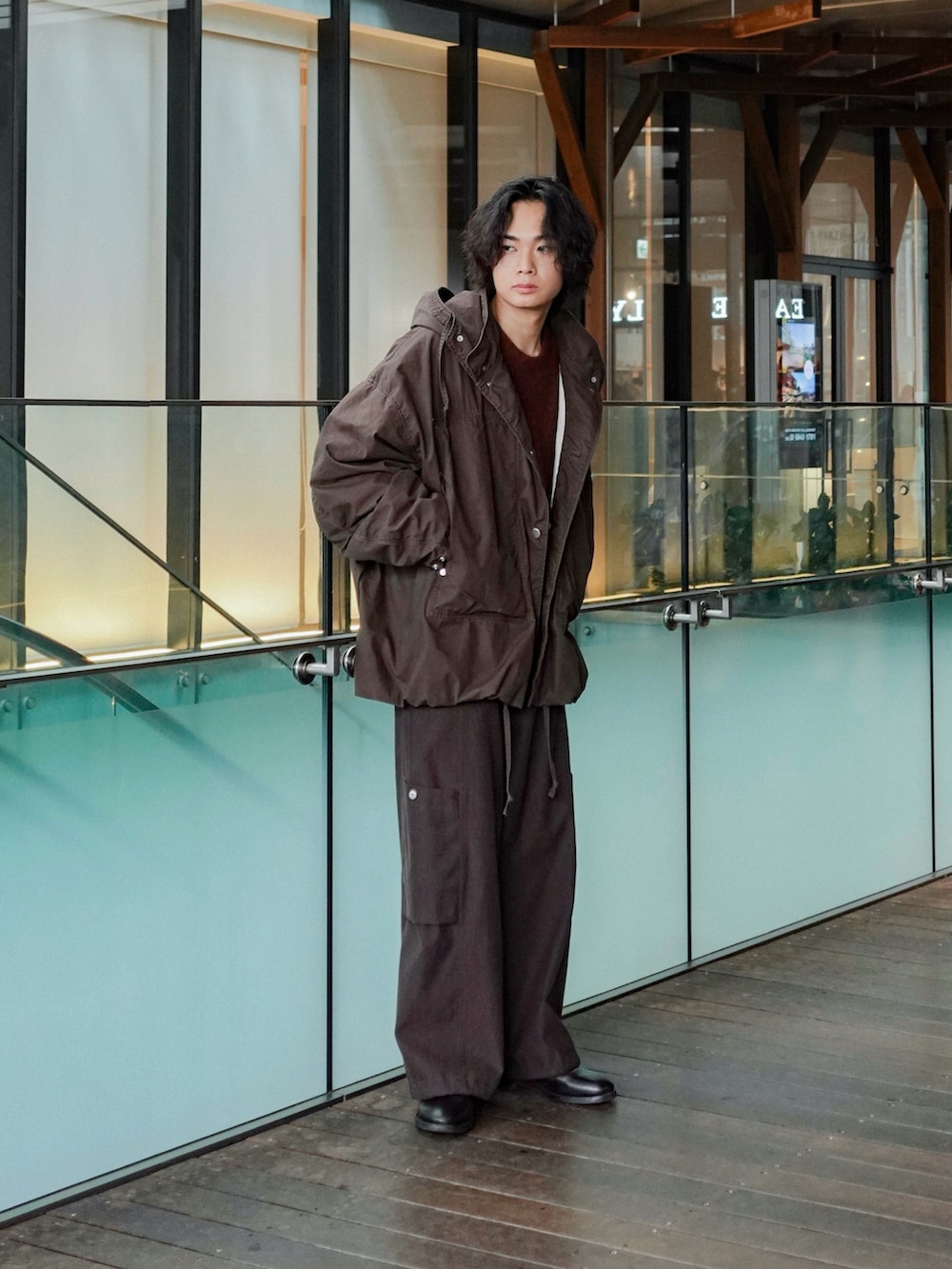 ブラック系のブーツ、ブラウン系のニット/セーター、ブラウン系のブルゾンを着用したメンズの秋コーディネートの2枚目の写真