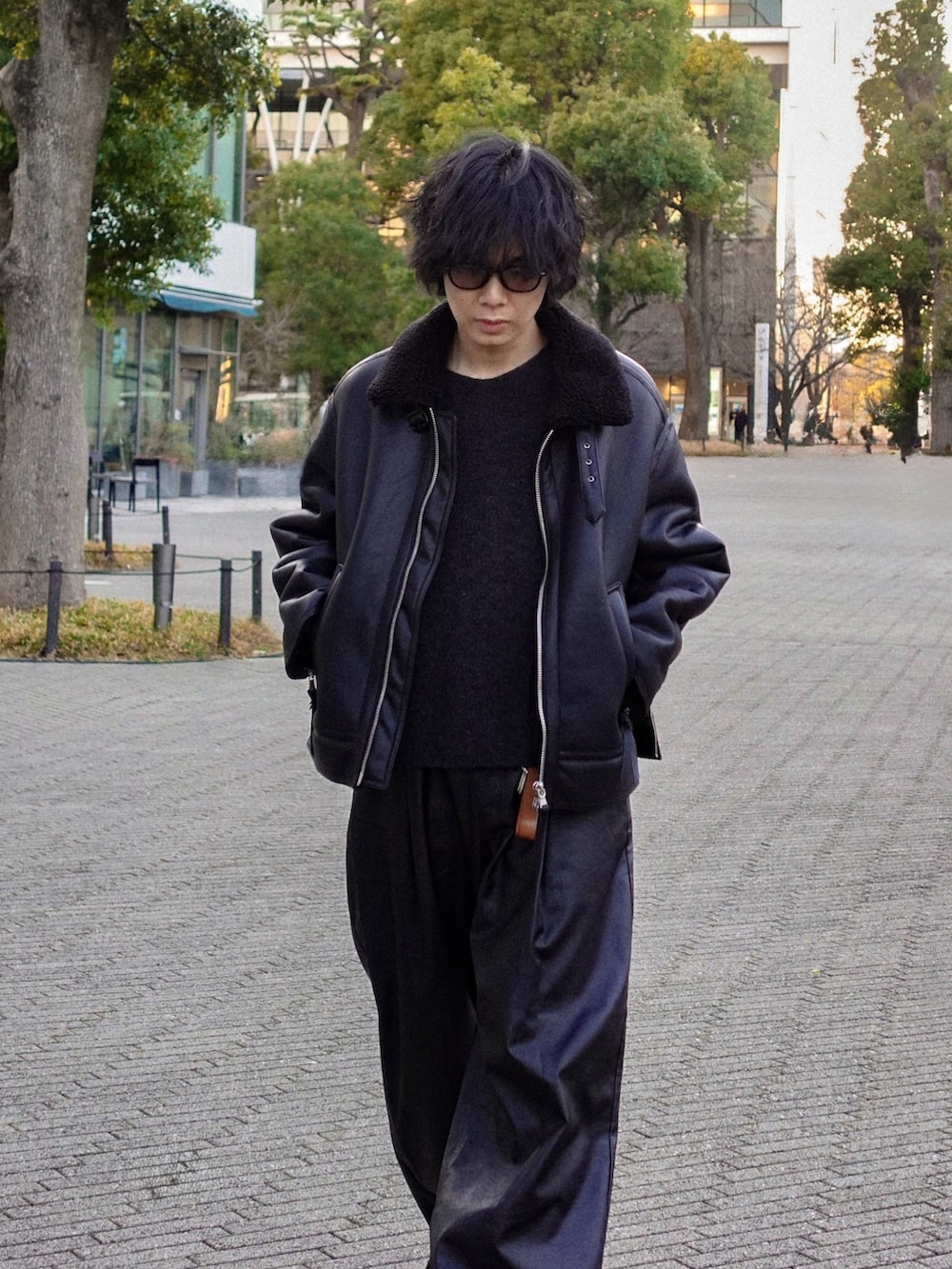 ブラック系のブルゾン、ブラック系のスラックス、ブラック系のドレスシューズを着用したメンズの冬コーディネートの2枚目の写真