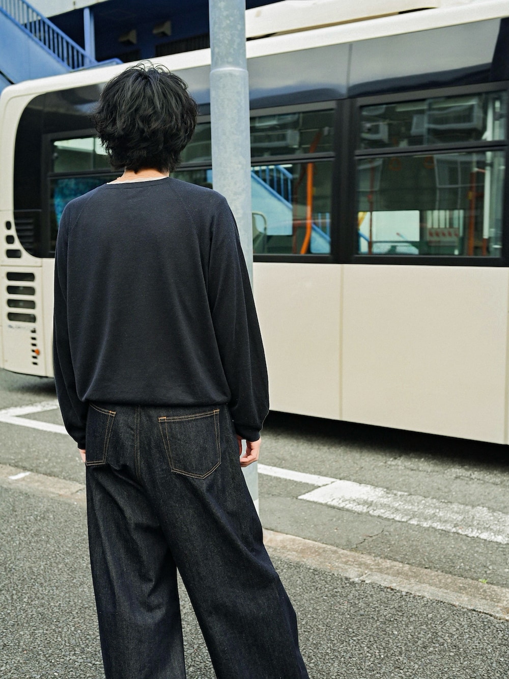 ブルー系のデニムパンツ、ブラック系のブーツ、ブラック系のニット/セーターを着用したメンズの春コーディネートの2枚目の写真