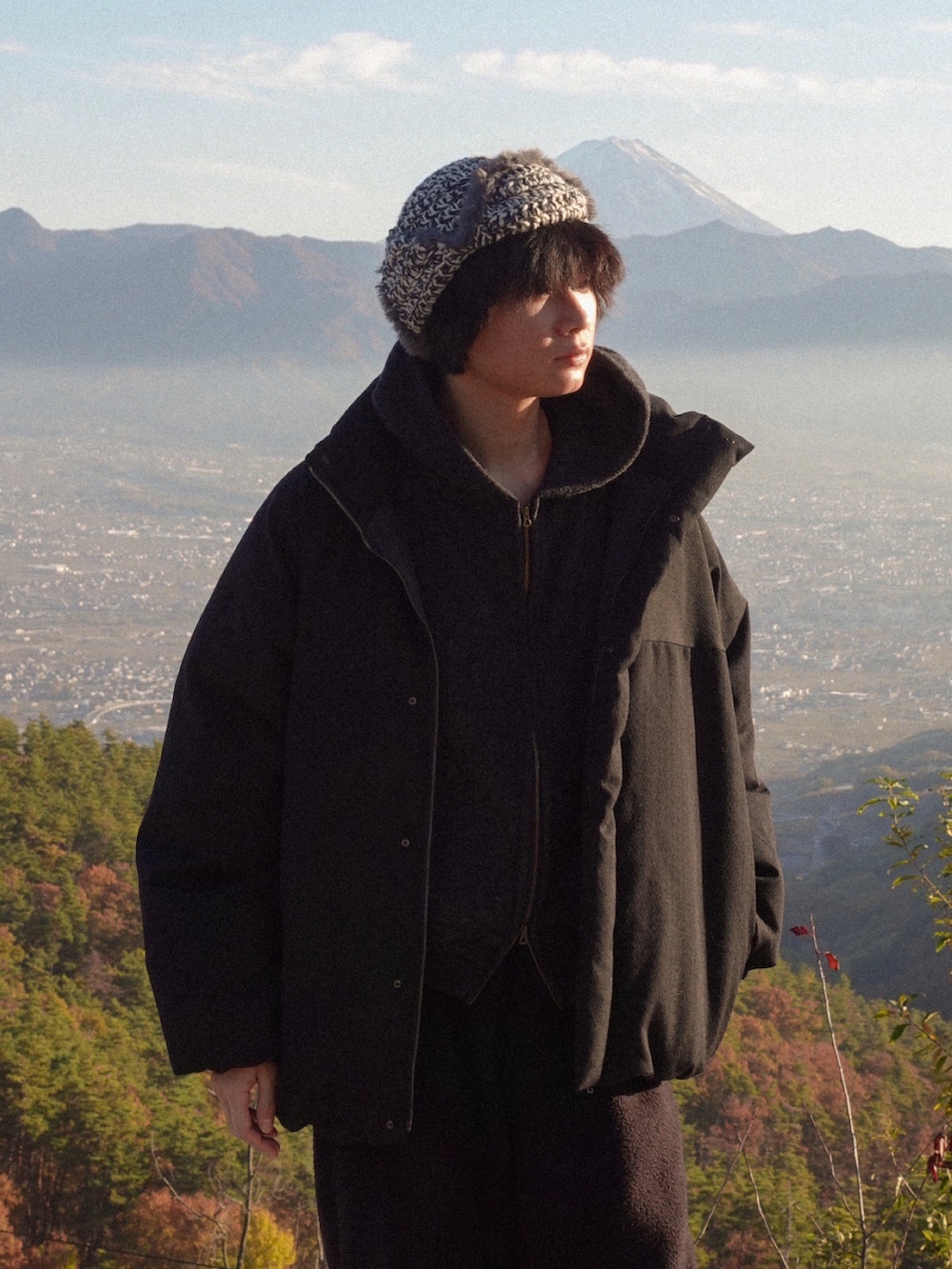 ブラック系のパーカー、ブラック系のダウンジャケット/コート、ブラック系のスニーカーを着用したメンズの秋コーディネートの2枚目の写真