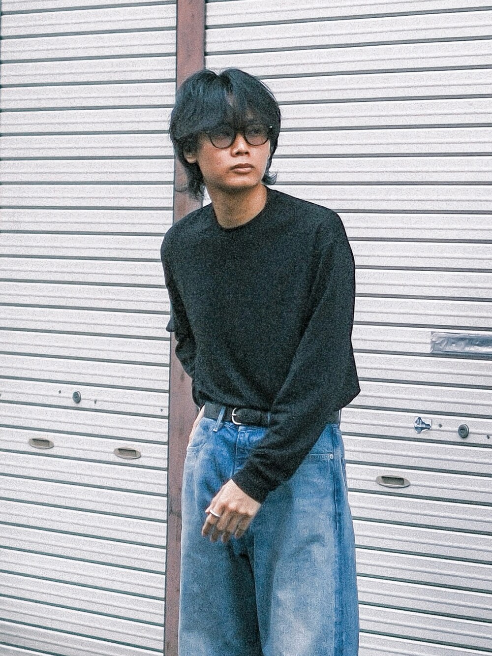 ブルー系のデニムパンツ、ブラック系のTシャツ/カットソー、ブラック系のスニーカーを着用したメンズの秋コーディネートの2枚目の写真