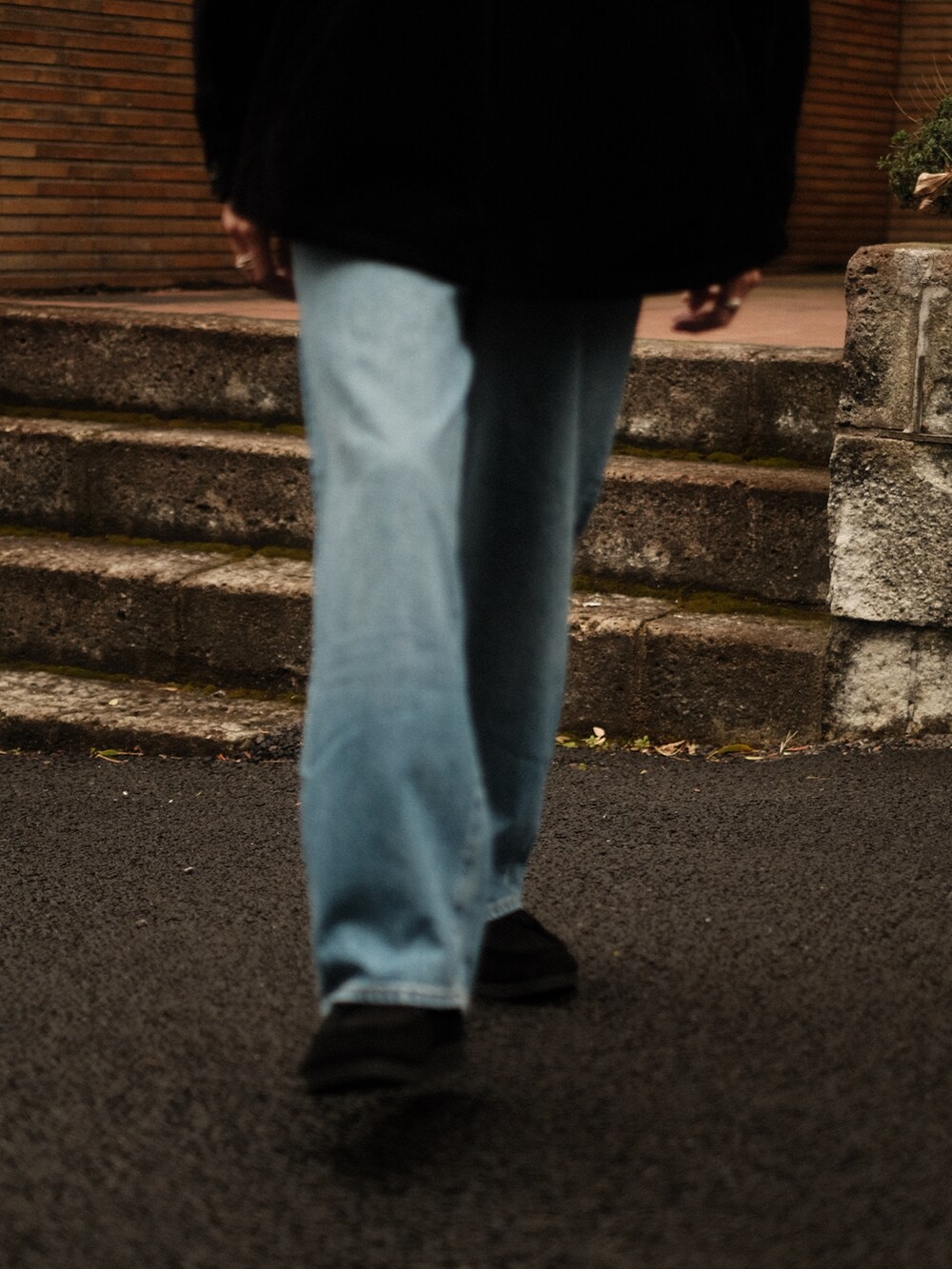 ブラック系のブルゾン、ブルー系のデニムパンツ、ブラック系のモカシン/デッキシューズを着用したメンズの冬コーディネートの3枚目の写真