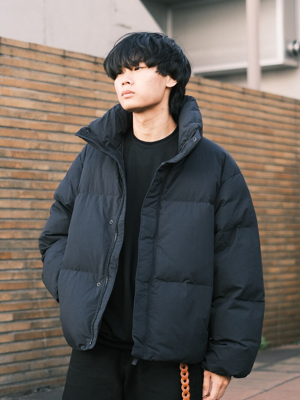 ブラック系のデニムパンツ、ブラック系のスニーカー、ブラック系のTシャツ/カットソーを着用したメンズの秋コーディネートの2枚目の写真