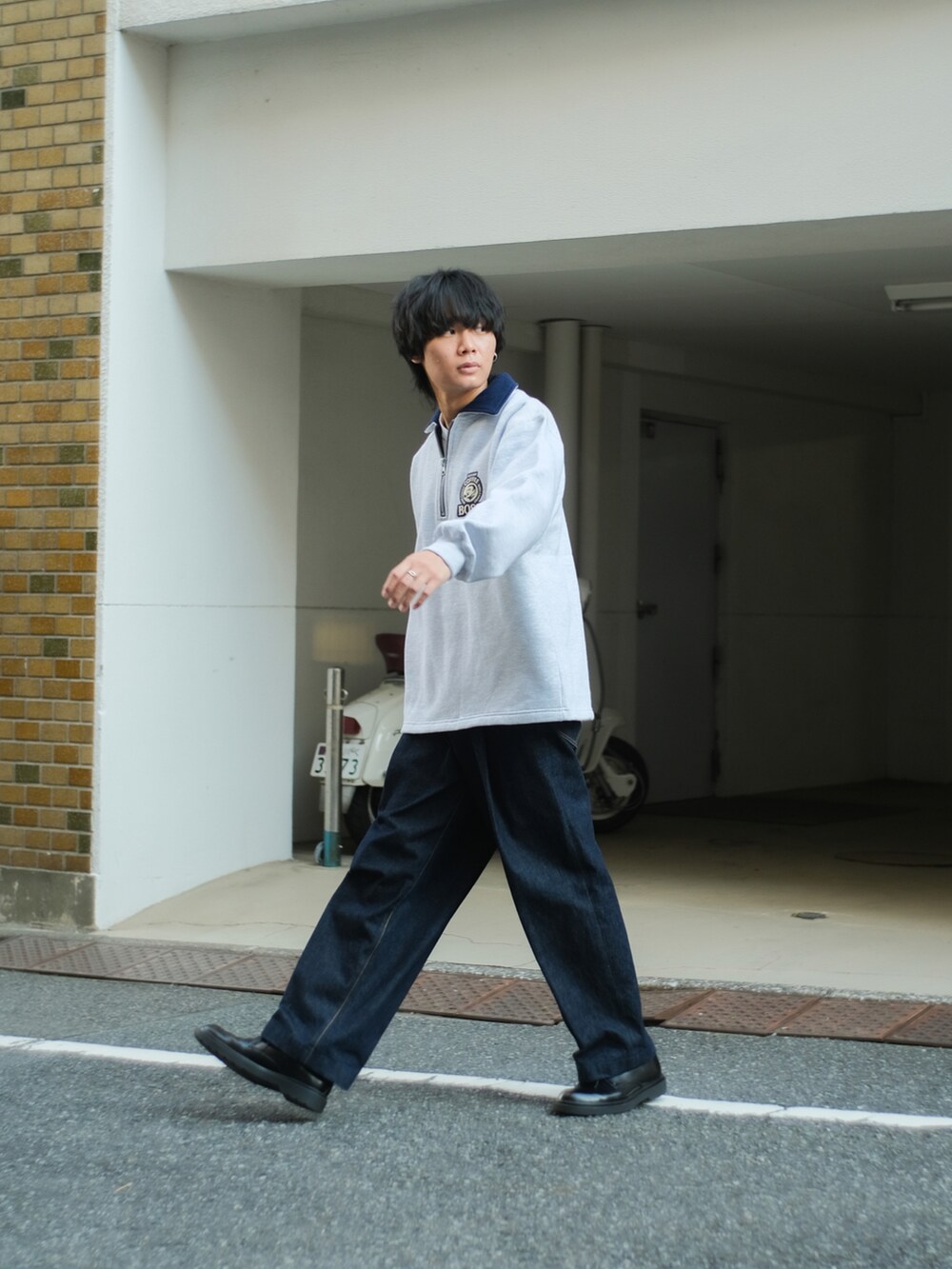 ブルー系のデニムパンツ、グレー系のスウェット、ブラック系のドレスシューズを着用したメンズの秋コーディネートの3枚目の写真