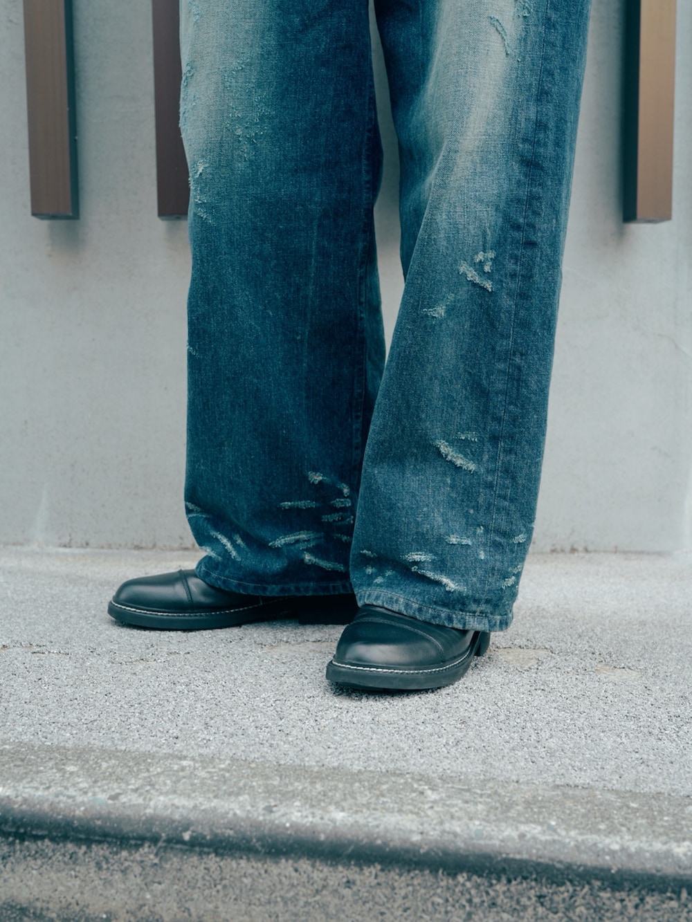 ブラック系のドレスシューズ、ブラウン系のニット/セーター、ブルー系のデニムパンツを着用したメンズの冬コーディネートの2枚目の写真