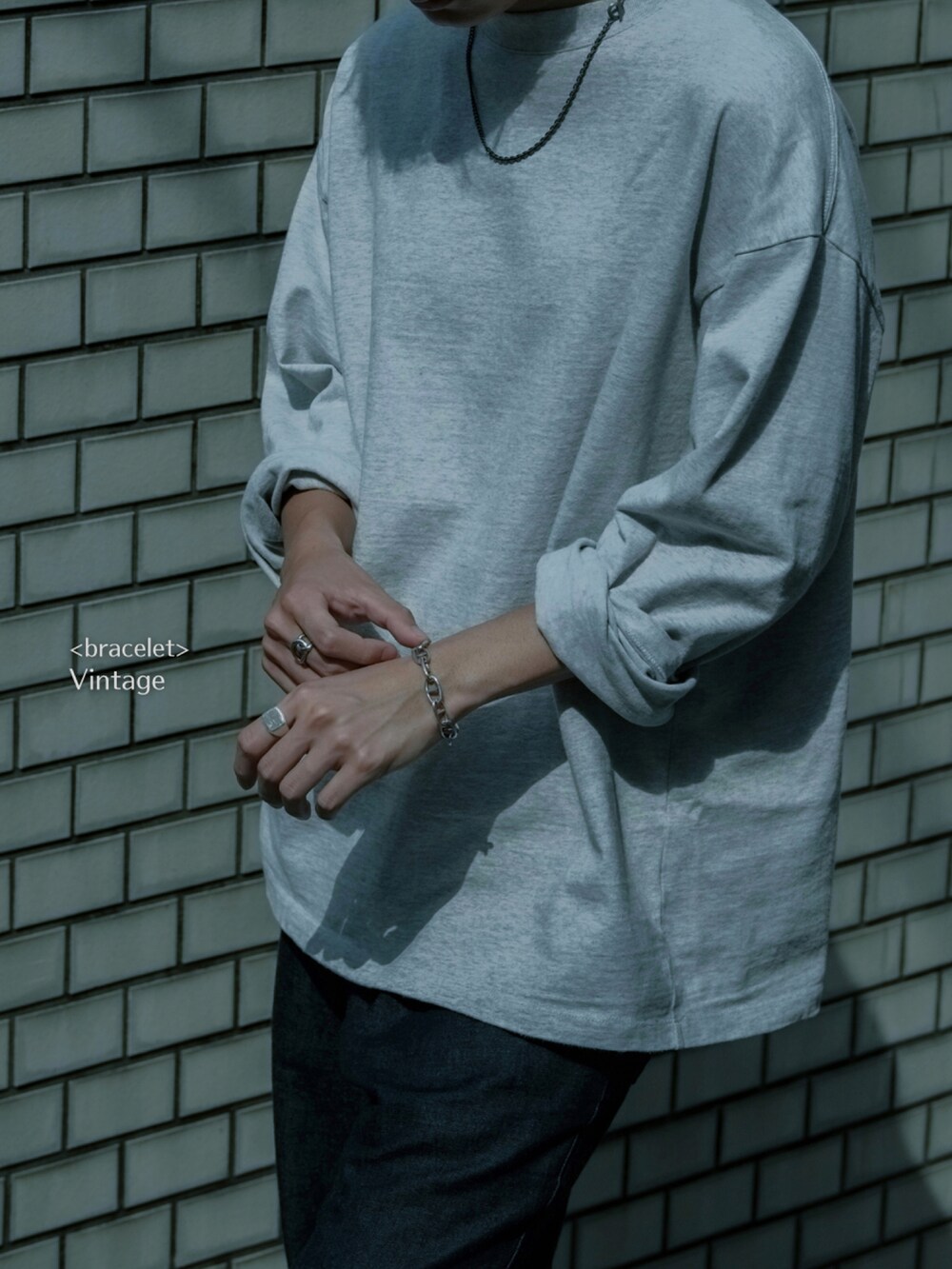 グレー系のTシャツ/カットソー、ブラック系のドレスシューズ、ブルー系のデニムパンツを着用したメンズの夏コーディネートの5枚目の写真