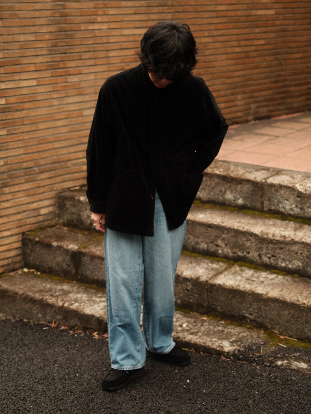 ブラック系のブルゾン、ブルー系のデニムパンツ、ブラック系のモカシン/デッキシューズを着用したメンズの冬コーディネートの4枚目の写真