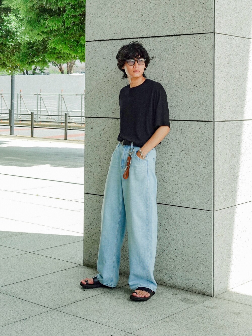 グレー系のTシャツ/カットソー、ブラック系のサンダル、ブルー系のデニムパンツを着用したメンズの夏コーディネートの2枚目の写真