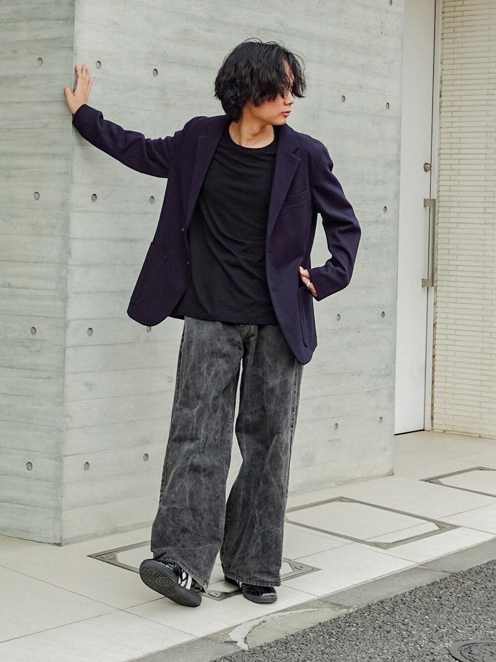 ブラック系のデニムパンツ、ブラック系のTシャツ/カットソー、ブラック系のスニーカーを着用したメンズの秋コーディネートの2枚目の写真