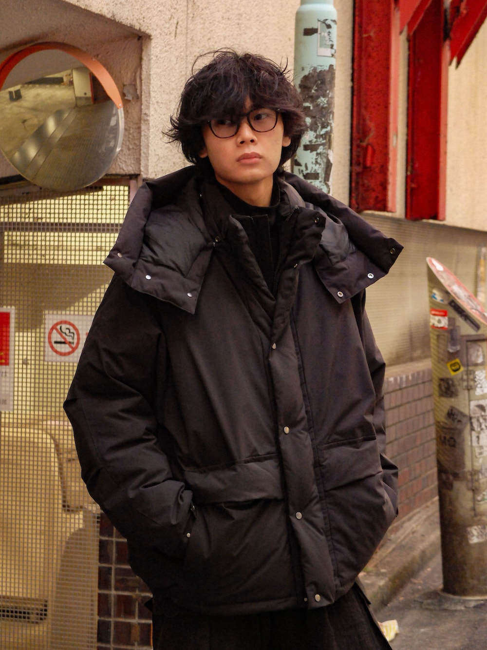 ブラック系のダウンジャケット/コート、ブラウン系のカーゴパンツ、ブラック系のブーツを着用したメンズの冬コーディネートの2枚目の写真