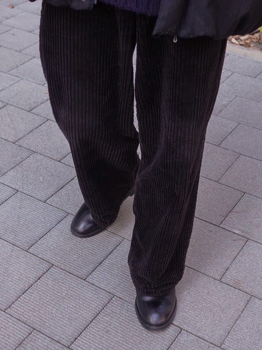 ブラック系のブーツ、ブラック系のダウンジャケット/コート、ブルー系のニット/セーターを着用したメンズの冬コーディネートの3枚目の写真