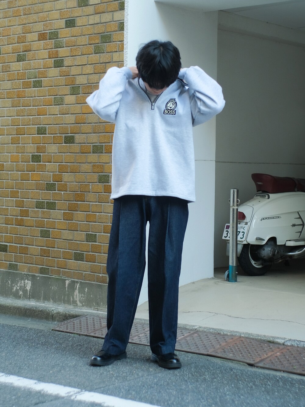 ブルー系のデニムパンツ、グレー系のスウェット、ブラック系のドレスシューズを着用したメンズの秋コーディネートの5枚目の写真