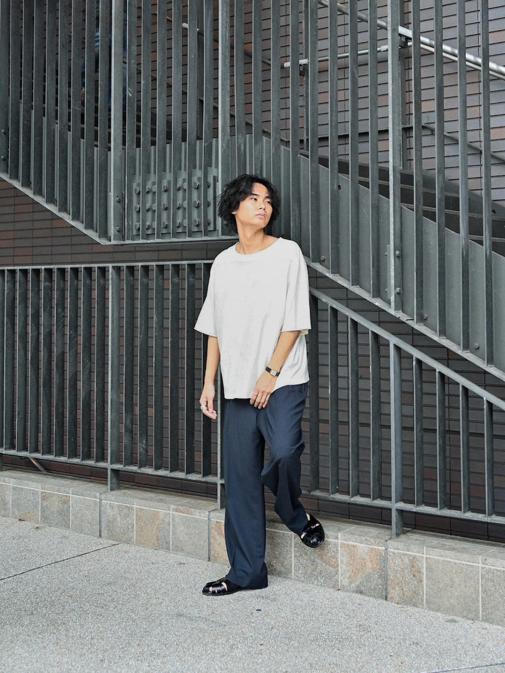 ブラック系のサンダル、ホワイト系のTシャツ/カットソー、ブラック系のスラックスを着用したメンズの夏コーディネートの2枚目の写真