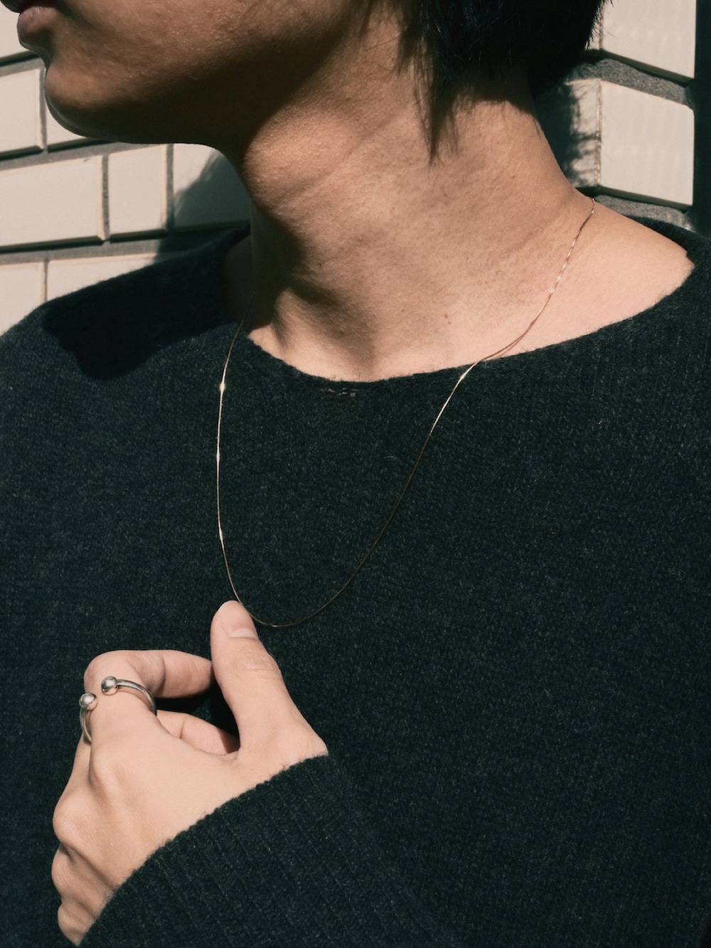 ブラック系のドレスシューズ、ブルー系のデニムパンツ、ブラック系のニット/セーターを着用したメンズの冬コーディネートの2枚目の写真