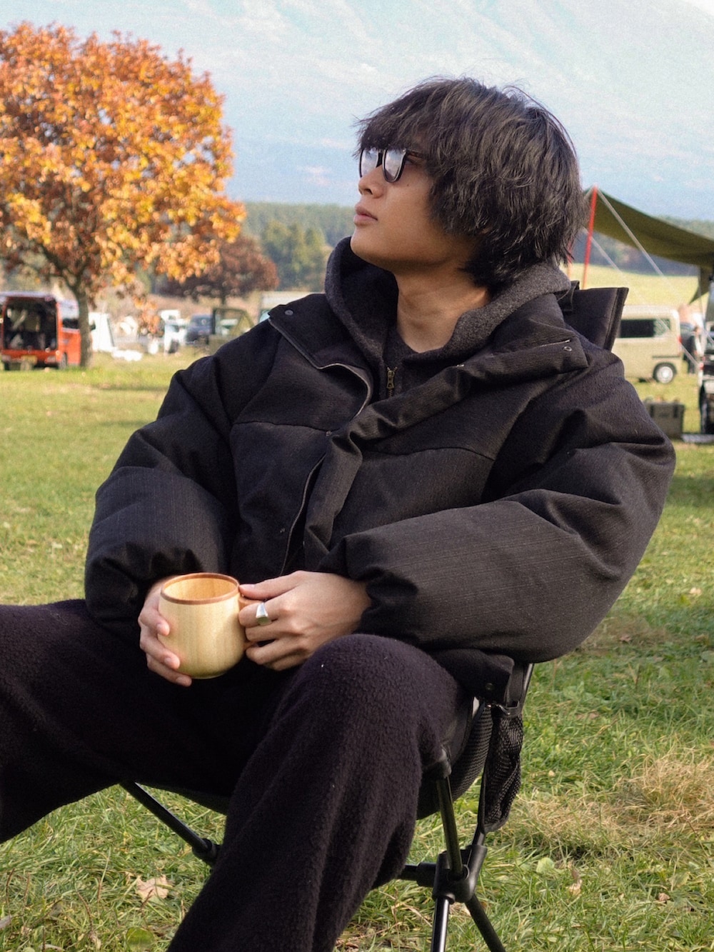 ブラック系のパーカー、ブラック系のTシャツ/カットソー、ブラック系のダウンジャケット/コートを着用したメンズの秋コーディネートの2枚目の写真