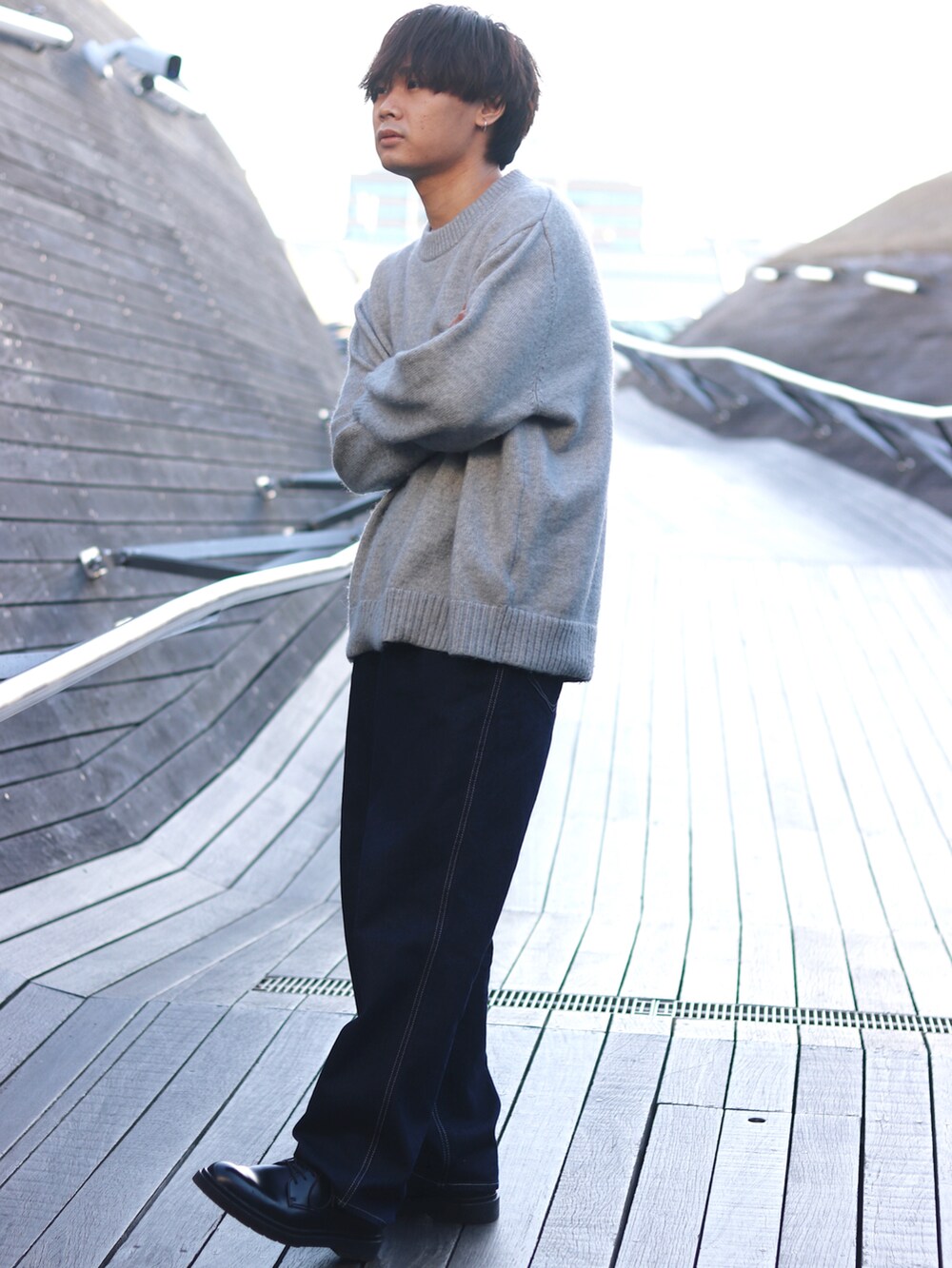 グレー系のニット/セーター、ブラック系のドレスシューズ、ブルー系のデニムパンツを着用したメンズの冬コーディネートの2枚目の写真