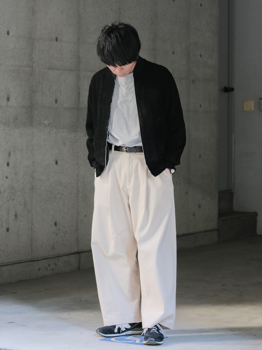 ブラック系のブルゾン、グレー系のTシャツ/カットソー、ホワイト系のその他パンツを着用したメンズの春コーディネートの2枚目の写真