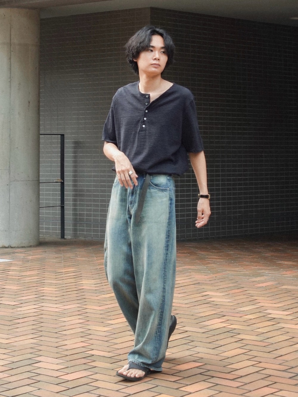 ブラック系のサンダル、ブルー系のデニムパンツ、ブラック系のTシャツ/カットソーを着用したメンズの夏コーディネートの4枚目の写真