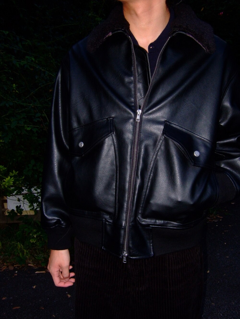 ブラック系のブルゾン、ブラック系のスニーカー、ブルー系のポロシャツを着用したメンズの秋コーディネートの2枚目の写真